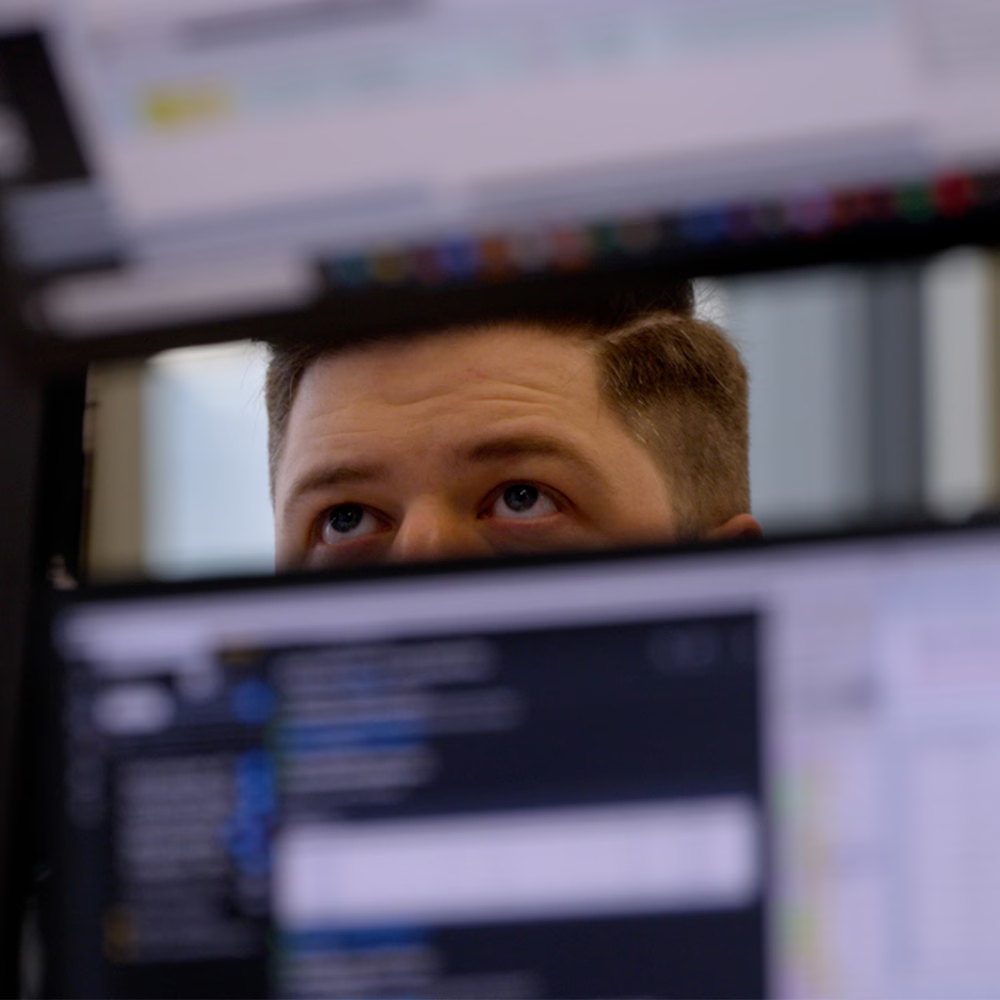 Analyst reviewing market data on screens